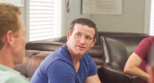 male looking at peer in his group therapy program 